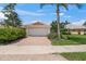 A well maintained garage with brick driveway, a tidy garden, and a sidewalk at 13391 Dimarco St, Venice, FL 34293