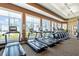 The gym features new treadmills and elliptical machines lined up by windows and an exit to a door at 13391 Dimarco St, Venice, FL 34293