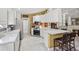 Bright kitchen featuring white cabinets, stainless steel appliances, and a cozy breakfast bar with seating at 13391 Dimarco St, Venice, FL 34293