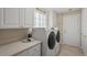 Bright laundry room with machines, cabinets, and a countertop at 13391 Dimarco St, Venice, FL 34293