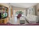 Spacious living room with ample natural light, tile flooring, built-in shelves, and a view of the outdoor pool area at 13391 Dimarco St, Venice, FL 34293