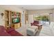 Relaxing living room with built-in shelves, and sliding glass doors opening to a pool area, all set on neutral tile flooring at 13391 Dimarco St, Venice, FL 34293