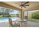 Relaxing covered patio with ceiling fan, overlooking screened pool and landscaping at 13391 Dimarco St, Venice, FL 34293