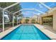Sparkling screened pool with blue tile trim and screened enclosure at 13391 Dimarco St, Venice, FL 34293