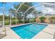 Dive into the screened pool with a view of the lake beyond the lush landscaping at 13391 Dimarco St, Venice, FL 34293