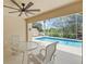 Screened-in pool area with table, chairs, and a view of the lush greenery at 13391 Dimarco St, Venice, FL 34293