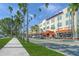 Street view of shops and restaurants lined with palm trees and parked cars at 13391 Dimarco St, Venice, FL 34293