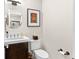 Powder room with stylish vanity, round mirror, artwork, and modern fixtures at 1347 Landings Dr # 6, Sarasota, FL 34231