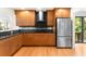 Stylish kitchen with wood cabinetry, stainless steel appliances, and black backsplash at 1347 Landings Dr # 6, Sarasota, FL 34231