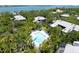 An aerial view showcases a private backyard swimming pool surrounded by mature trees and lush tropical foliage at 1347 Landings Dr # 6, Sarasota, FL 34231