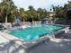 Community pool featuring lounge chairs, umbrellas, and tropical landscaping at 1347 Landings Dr # 6, Sarasota, FL 34231