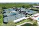 Aerial view of multiple well-maintained tennis courts with green canopies, surrounded by lush landscaping in a waterfront community at 1347 Landings Dr # 6, Sarasota, FL 34231