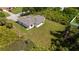 An aerial view of a modern home with a lush green lawn and mature trees surrounding the property at 1532 Maricopa Rd, North Port, FL 34287