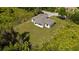 An aerial perspective of a modern home with a well-maintained lawn surrounded by verdant trees and shrubbery at 1532 Maricopa Rd, North Port, FL 34287