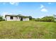 Grassy backyard featuring a modern home in the background at 1532 Maricopa Rd, North Port, FL 34287