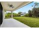 View of grassy backyard from covered patio, featuring ceiling fan at 1532 Maricopa Rd, North Port, FL 34287