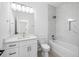 Bright bathroom featuring vanity, toilet, and tiled shower-tub combo with a glass shower panel at 1532 Maricopa Rd, North Port, FL 34287