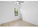 Sunlit bedroom featuring a ceiling fan, window views, and an adjacent doorway at 1532 Maricopa Rd, North Port, FL 34287