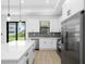 Well-equipped kitchen featuring stainless steel appliances, white cabinets, quartz countertops, and backyard access at 1532 Maricopa Rd, North Port, FL 34287