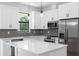 Modern kitchen with stainless steel appliances, white cabinets, granite countertops, and stylish pendant lighting at 1532 Maricopa Rd, North Port, FL 34287