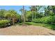 Landscaped backyard with lush trees and greenery, and a pebble groundcover at 1627 Peregrine Point Ct, Sarasota, FL 34231