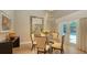 Bright dining room featuring a glass-top table, modern chandelier, large mirror, and french doors to the outside at 1627 Peregrine Point Ct, Sarasota, FL 34231
