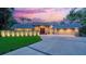 Stunning exterior view of a modern home featuring a two-car garage, a secure gate, and lush landscaping at 1627 Peregrine Point Ct, Sarasota, FL 34231