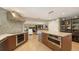 Contemporary kitchen with mosaic backsplash, stainless hood, island and views to the living room at 1627 Peregrine Point Ct, Sarasota, FL 34231