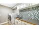 Functional laundry room with a washer and dryer, ample counter space, and stylish mosaic tile at 1627 Peregrine Point Ct, Sarasota, FL 34231
