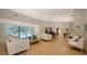Expansive living room featuring hardwood floors, neutral walls, a grand piano, modern furnishings, and pool views at 1627 Peregrine Point Ct, Sarasota, FL 34231