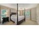 Elegant bedroom with a four-poster bed, side tables, and large windows bringing in natural light at 1627 Peregrine Point Ct, Sarasota, FL 34231