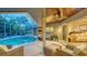 A shaded lanai next to the pool featuring wicker furniture, ceiling fan, and views into the house at 1627 Peregrine Point Ct, Sarasota, FL 34231