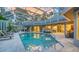 Screened pool with several seating areas, a built-in kitchen bar and a screened enclosure with sunset reflections at 1627 Peregrine Point Ct, Sarasota, FL 34231