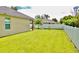 Lush, fenced backyard with ample green space, covered patio, and outdoor seating at 1646 Pierpoint St, North Port, FL 34288