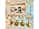 Modern kitchen boasts a large island with seating and stylish gold and beige stools at 1646 Pierpoint St, North Port, FL 34288