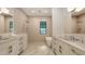 Luxurious bathroom with double vanities, soaking tub, and rainfall shower, all with elegant fixtures at 1658 Bonita Ln, Sarasota, FL 34239