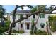 Elegant two-story home featuring a balcony, black-framed windows, and beautifully landscaped front yard with tropical foliage at 1658 Bonita Ln, Sarasota, FL 34239