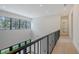 Upstairs hallway with high ceilings, black metal handrail, and large windows showcasing the outdoor scenery at 1658 Bonita Ln, Sarasota, FL 34239