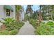 Walkway alongside house featuring lush landscaping with a variety of tropical plants and shrubbery at 1658 Bonita Ln, Sarasota, FL 34239
