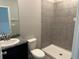 Tiled bathroom featuring a sleek shower, granite vanity, and modern fixtures at 17637 Cantarina Cv, Bradenton, FL 34211