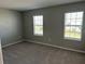 Cozy bedroom with plush carpeting and natural light from two windows at 17637 Cantarina Cv, Bradenton, FL 34211