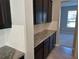 Butler pantry boasts dark cabinets, granite countertops, and white subway tile backsplash at 17637 Cantarina Cv, Bradenton, FL 34211