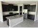 Modern kitchen with stainless steel appliances, dark cabinets, and gray granite countertops at 17637 Cantarina Cv, Bradenton, FL 34211