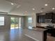 A stunning kitchen with dark cabinets, granite counters, and stainless steel appliances overlooking the patio at 17637 Cantarina Cv, Bradenton, FL 34211