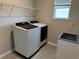 Functional laundry room with a modern washer and dryer, convenient sink, and overhead shelving for storage at 17637 Cantarina Cv, Bradenton, FL 34211