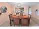 Dining room with wooden table set and adjacent view into the kitchen at 1959 Toucan Way # 206, Sarasota, FL 34232