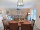 Cozy dining room features a wood table, seating for six, and a modern light fixture, perfect for Gathering meals at 1959 Toucan Way # 206, Sarasota, FL 34232