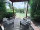 The covered patio features comfortable seating with lush greenery surrounding the outdoor space at 1959 Toucan Way # 206, Sarasota, FL 34232