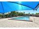 Beautiful community pool under a shade, boasting crystal-clear water, inviting seating, and lush landscaping at 2103 Harbourside Dr # 1102, Longboat Key, FL 34228