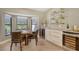 Dining room with bar featuring a wine refrigerator, custom shelves and a view of the golf course at 2103 Harbourside Dr # 1102, Longboat Key, FL 34228